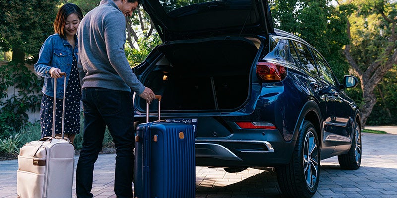 Couple putting their bags in boot of Buick Encore GX